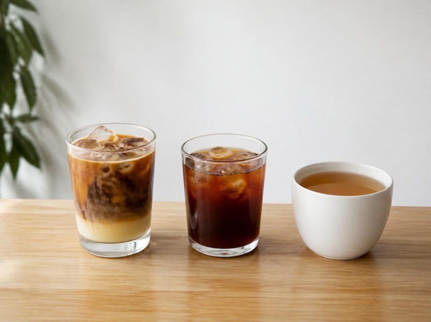 Vietnamese iced coffee, cold brew and a cup of hot tea on a wooden counter